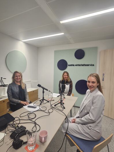3 Frauen rund um den Tisch mit Podcast-Mikrofon